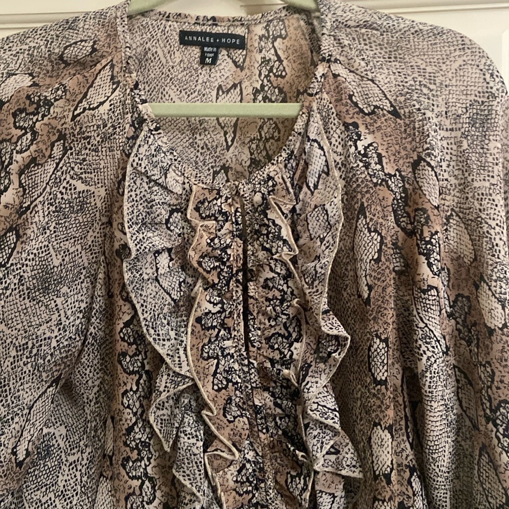 Puffy sleeves,ruffles 1/2 way down front opening. 100% polyester.